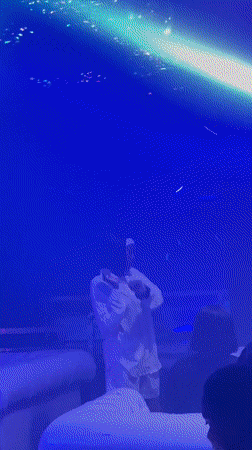 Nigerian nightclub scene with DJ, dancers, and illuminated props