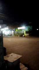 Nighttime street traffic along a Bandung commercial strip
