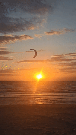 Kitesurfer captured against vibrant sunset at Ukrainian coastal town