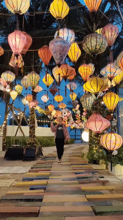 Woman poses among illuminated lanterns in Vietnam tourist area