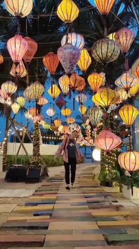 Woman poses among illuminated lanterns in Vietnam tourist area