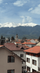 Aerial view captures Bansko's red rooftops against snowy mountains