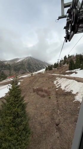 Ski lift ride filmed on patchy snow slopes near Almaty