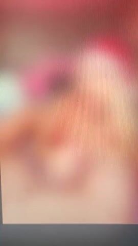 The video shows a close-up, blurry image of a person wearing a Santa hat. The person's face is not clearly visible due to the blurriness and the angle. The background is also out of focus. The overall impression is of a festive, possibly holiday-themed, scene.