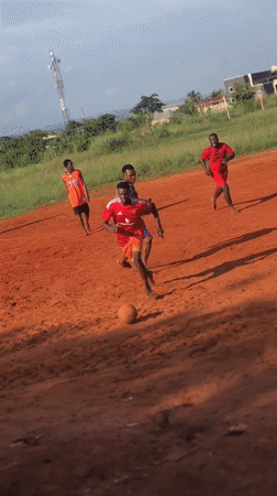 Barefoot football match played on dirt field in Nsugbe