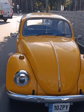 Yellow VW Beetle spotted near Tallinn ruins on a sunny afternoon