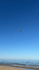 Paraglider flies over beach in Castelló de la Plana