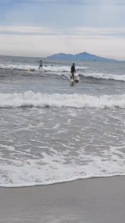Surfers riding waves off the coast of Da Nang