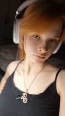 Woman with red hair wearing headphones captured on video