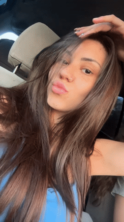 Woman poses, winks at camera inside car in Bulgaria