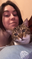 Woman and tabby cat share quiet moments in Odesa bedroom