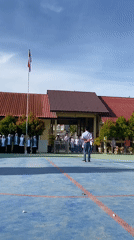 School assembly in formation on a blue outdoor court