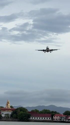 Plane on final approach over Ko Samui's coastal waters