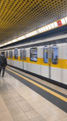 White-yellow subway train arrives at Milan station