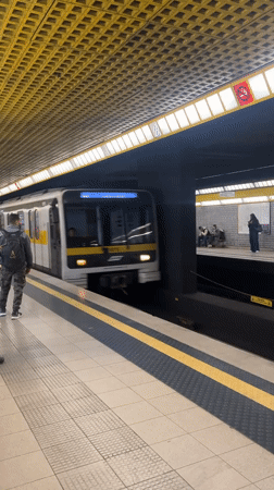 White-yellow subway train arrives at Milan station