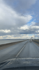 Driver records wet road journey past water body in Russia