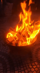 Fire burns in metallic pit on tiled surface in Ribeira Grande