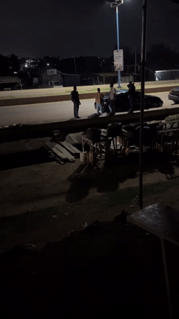 Group gathers around stopped sedan in Offatedo, Nigeria