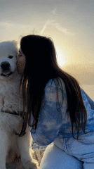 Woman and Samoyed dog share sunset moment on Montenegro beach