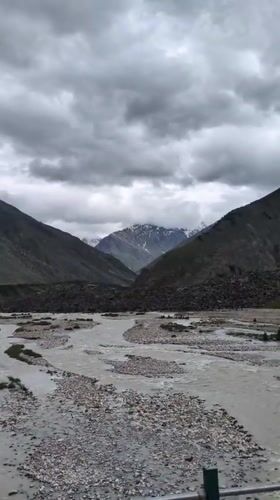 Darcha's rocky river valley and bridge under heavy cloud cover