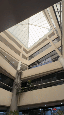 Multi-story building interior with pyramid skylight captured in Porlamar
