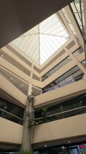 Multi-story building interior with pyramid skylight captured in Porlamar