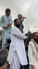 Street gathering with speakers and security presence in Quetta