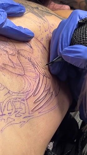 Tattoo artist works on angel design in Buenos Aires