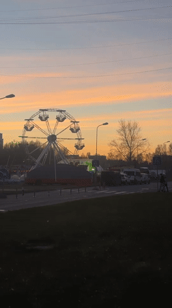 Sunset Ferris wheel creates striking silhouette over Riga skyline