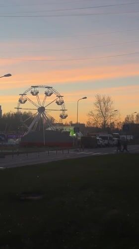 Sunset Ferris wheel creates striking silhouette over Riga skyline