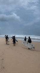 Surfers hit Kathaluwa Beach under stormy skies