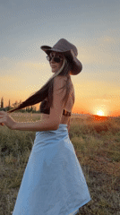 Sunset poses in a Russian field, cowboy hat and summer clothes.