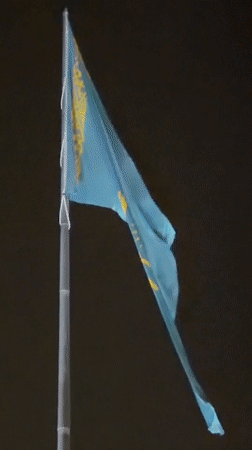 Kazakhstan's flag flies against a dark Astana sky