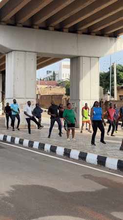 Outdoor group exercise class under a Jos overpass