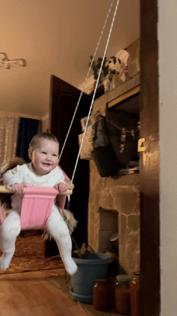 Two babies play on carpet in Novopokrovskaya home