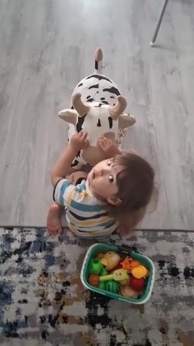 Morning domestic routine: child plays, adult makes juice in Kempelevo