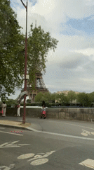 Tourists photograph Eiffel Tower during cloudy afternoon in Paris