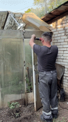 Man repairs old greenhouse entrance in Izhevsk