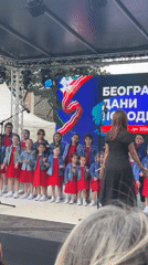 Children's choir performs outdoors in Belgrade, red dresses and denim