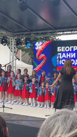 Children's choir performs outdoors in Belgrade, red dresses and denim