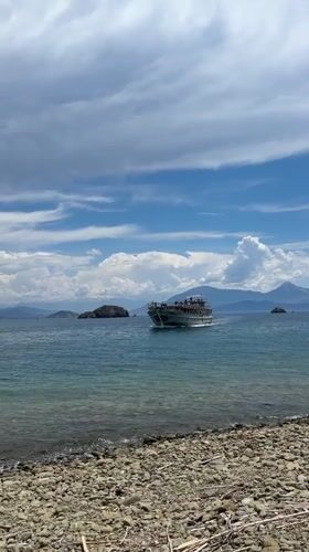Ferry crosses clear waters near Fethiye under cloudy skies