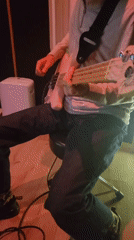Musician plays white bass guitar in recording studio