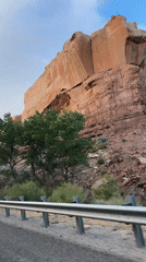 Driving past towering sandstone cliffs in Bluff, Utah