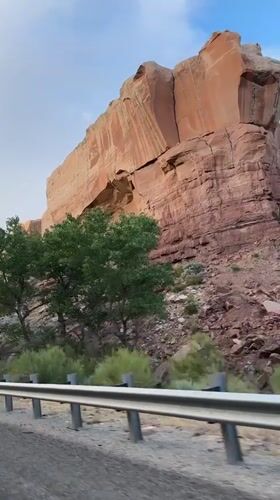 Driving past towering sandstone cliffs in Bluff, Utah