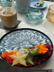 Woman enjoys decorated smoothie bowl at Ubud cafe
