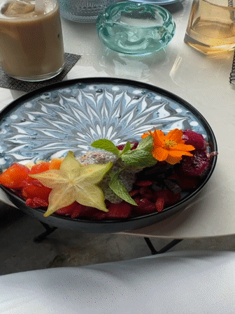 Woman enjoys decorated smoothie bowl at Ubud cafe