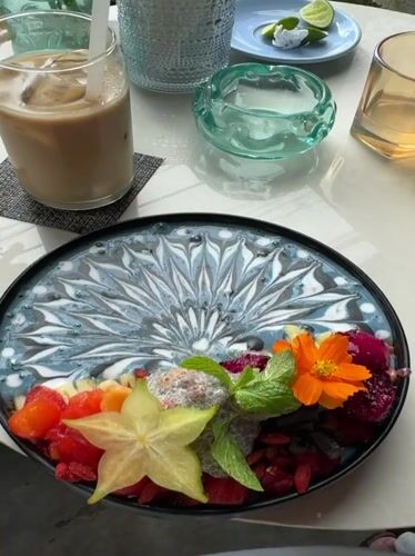 Woman enjoys decorated smoothie bowl at Ubud cafe