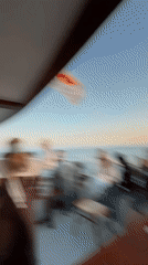 Boat passengers photograph planes and sunset near Larnaca airport