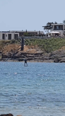 Paddleboarding, hydrofoiling, and water skiing off a rocky coast