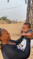 Woman plays with baby outside in Sabon Tasha, Nigeria